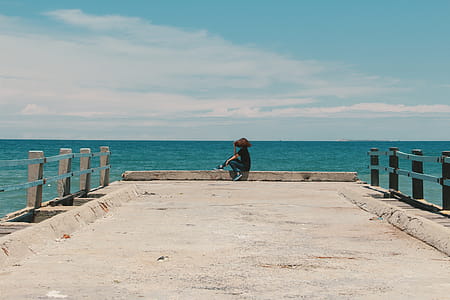Person Sitting on the Edge of the Beach Dock thumbnail