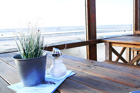 clear bottle beside gray pot on brown wooden surface thumbnail