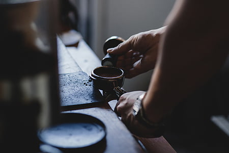 man holding black hand tool standing near table thumbnail