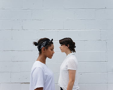 two woman standing facing each other thumbnail