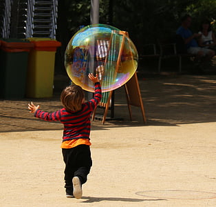 boy playing with bubble during daytime thumbnail