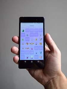 person holding turned-on smartphone displaying game thumbnail