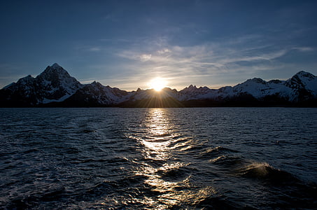 photo of body of water near mountain range thumbnail