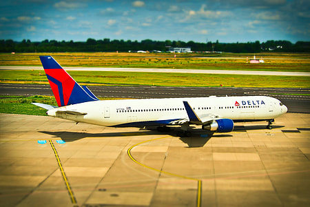 white and blue Delta airplane in airport thumbnail