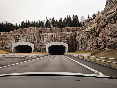 Photo of Two Highway Tunnels in Cliff Under Cloudy Sky thumbnail