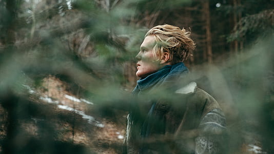 man standing surrounded by trees thumbnail
