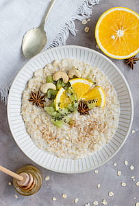 white ceramic bowl filled with oatmeal and sliced orange on top thumbnail