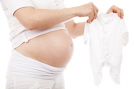 woman holding baby's white footie pajama thumbnail