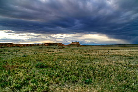 Dark roiling clouds above a sweeping grass floor envelope rock formations creating an enchanted dreamlike visage. This is Pawnee National Grasslands, Colorado, during early spring. These grasslands are located on the Colorado prairie near the Wyoming state line. thumbnail