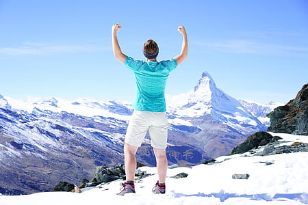 man wearing blue shirt standing on snowy area thumbnail