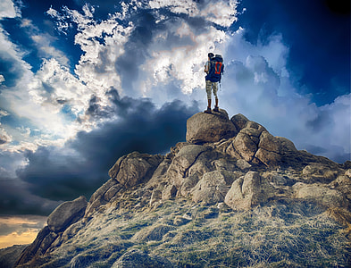 person with hiking standing on stone on top of hill thumbnail