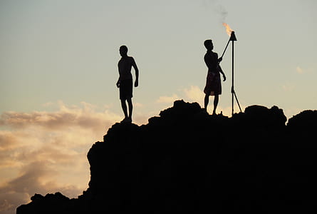 silhouette of two man standing on peak during daytime thumbnail