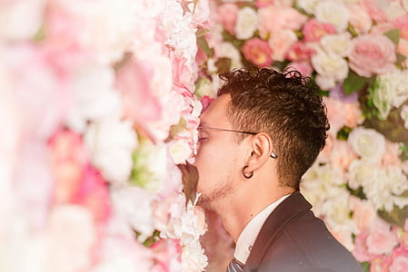 man smelling pink petaled flowers thumbnail