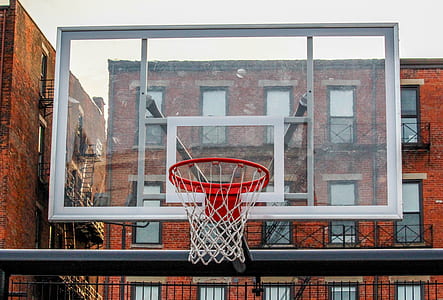 white and clear glass basketball hoop with board near brown concrete building thumbnail