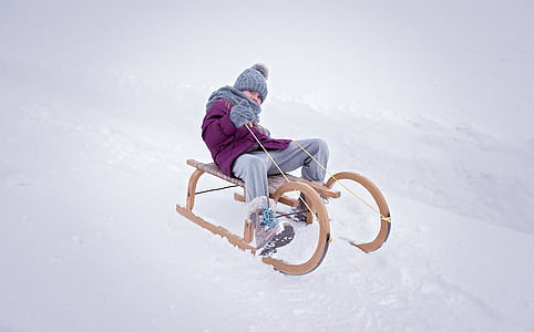 boy riding brown sled thumbnail