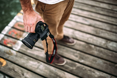 Photographer holding a DSLR camera thumbnail