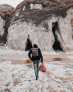 person walking in front of stone thumbnail