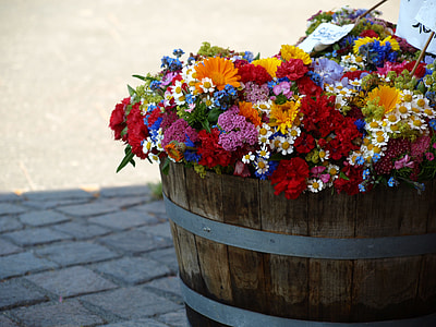 assorted color petaled flowers on brown wooden vase on gray concrete pavement during daytime thumbnail