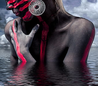woman in white hoop earring and red body paint on body of water thumbnail