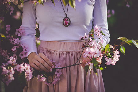 woman holding pink petaled flowers thumbnail