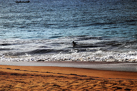 person in sea beside seashore during daytime thumbnail