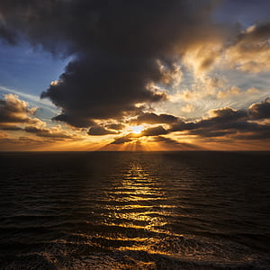 ocean under cloudy sky during sunset thumbnail