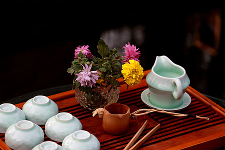 green and white ceramic saucer bowl near vase with flowers thumbnail