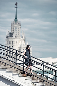 depth of field photography of woman walking down the stairs thumbnail