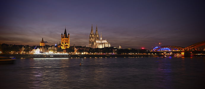 high rise concrete buildings near calm body of water at nighttime thumbnail