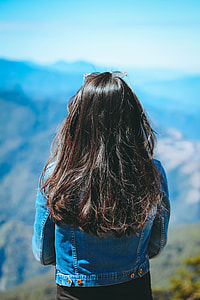 woman standing on cliff during daytime thumbnail