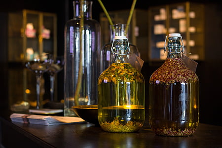 two clear glass bottles on brown wooden table thumbnail