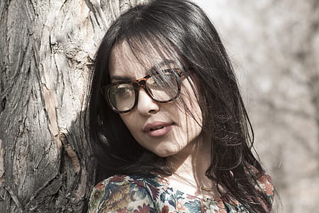 woman wearing eyeglasses leaning on tree bark thumbnail