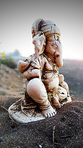 brown Ganesh figurine on brown sand thumbnail