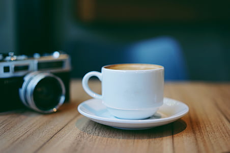 white ceramic cup and saucer on brown surface thumbnail