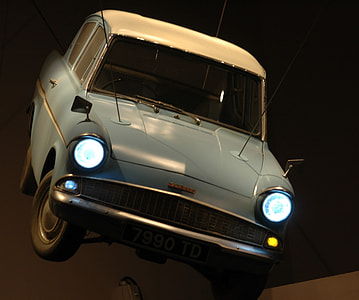 classic blue vehicle with turned-on headlights at night thumbnail