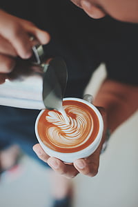 person pouring foam topping on latte thumbnail