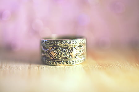 selective focus photo of gold-colored ring on beige surface thumbnail