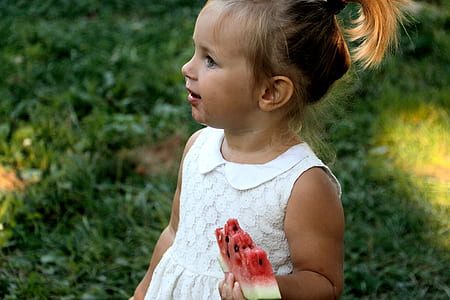 girl standing holding watermelon thumbnail