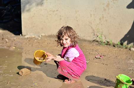 girl wearing pink dress holding yellow plastic dipper thumbnail