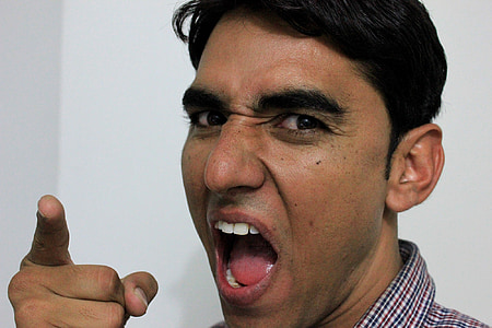 man with mouth wide opened standing near white wall thumbnail