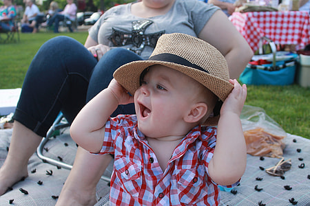 baby in red and white plaid button-up shirt wearing brown hat thumbnail