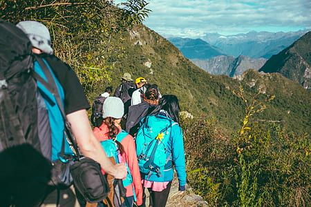 group of people trekking on mountain top thumbnail
