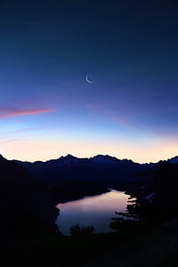 silhouette aerial photography of river under crescent moon thumbnail