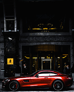 red Mercedes-Benz AMG GT parked near black concrete building with glass door thumbnail