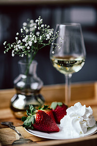 Strawberries with cream and glass of white wine on wooden tray thumbnail