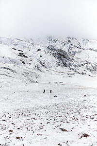 two person walking along snow covered hill thumbnail