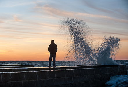 man in black jacket standing on brown dock thumbnail