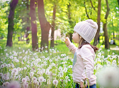 boy wearing white knit cap holding white flower thumbnail
