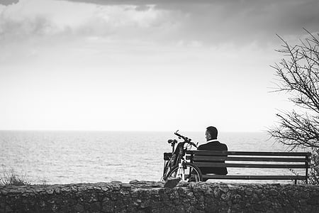 man in black suit jacket beside sea shore thumbnail