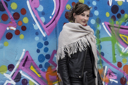 woman wearing black leather jacket and brown scarf thumbnail